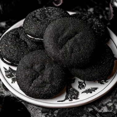 A plate of Black Velvet Cheesecake Cookies with a rich chocolate drizzle