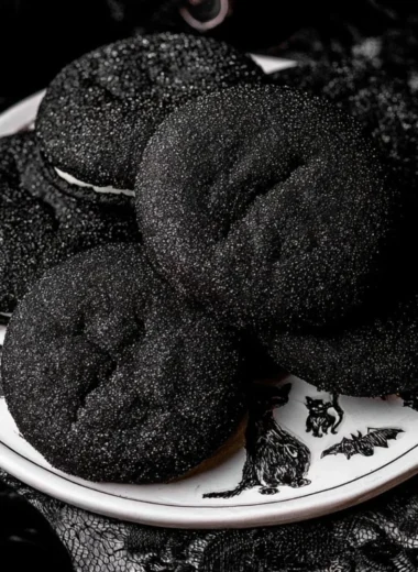 A plate of Black Velvet Cheesecake Cookies with a rich chocolate drizzle
