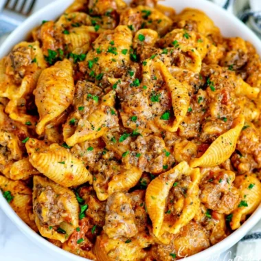 Cozy creamy beef and shells dish served in a bowl, garnished with parsley.