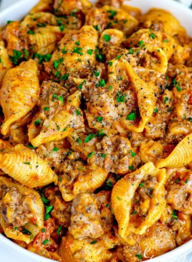 Cozy creamy beef and shells dish served in a bowl, garnished with parsley.