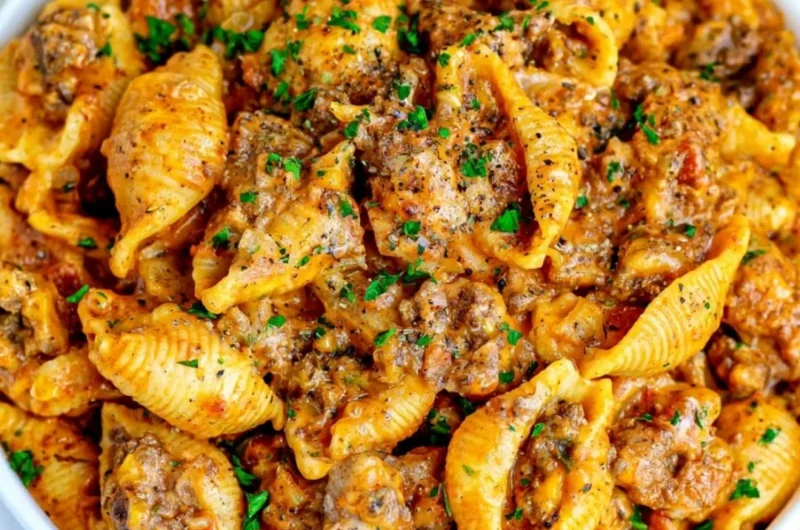 Cozy creamy beef and shells dish served in a bowl, garnished with parsley.