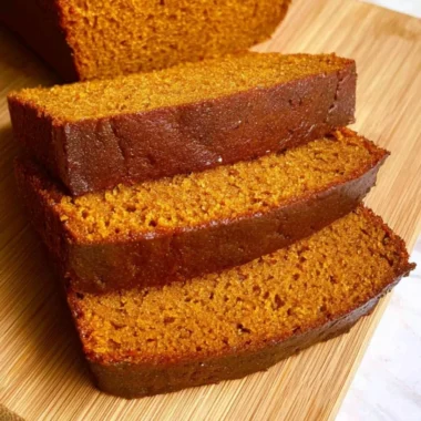 Slice of cozy easy pumpkin bread topped with spices and pumpkin seeds