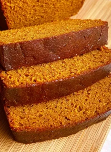 Slice of cozy easy pumpkin bread topped with spices and pumpkin seeds