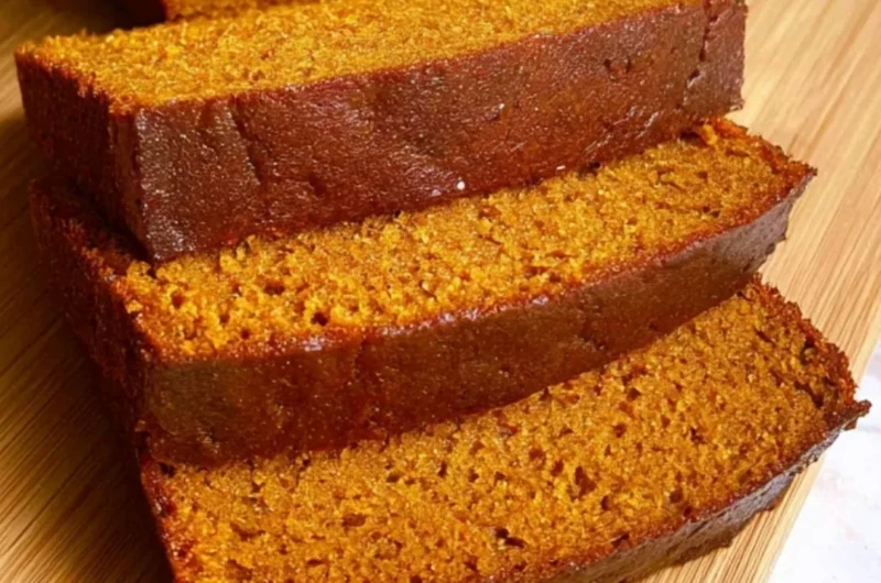 Slice of cozy easy pumpkin bread topped with spices and pumpkin seeds