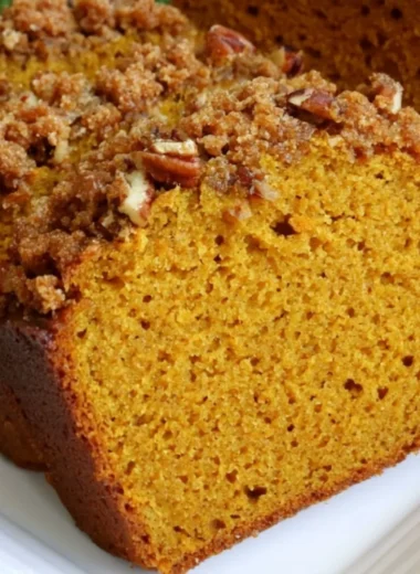 Delicious homemade pumpkin bread topped with spices and nuts
