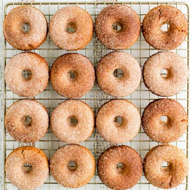 Cozy pumpkin spice donuts topped with icing and sprinkled with cinnamon.