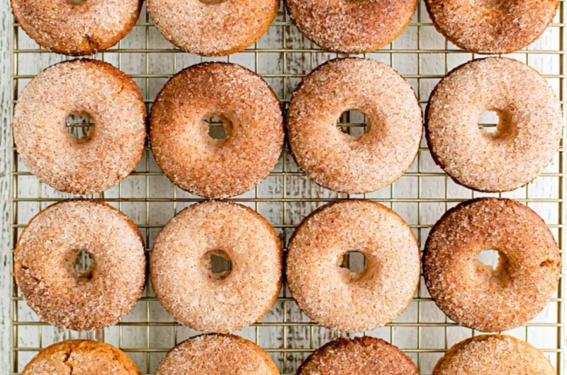 Cozy pumpkin spice donuts topped with icing and sprinkled with cinnamon.
