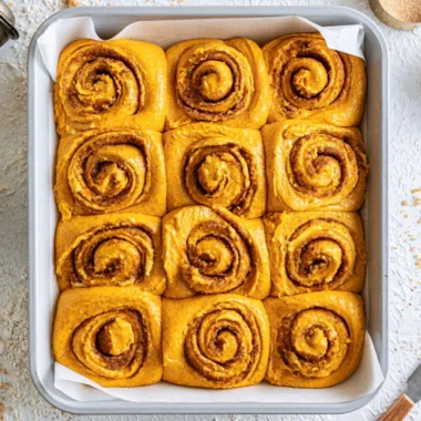 Delicious pumpkin cinnamon rolls topped with cream cheese icing, perfect for fall.