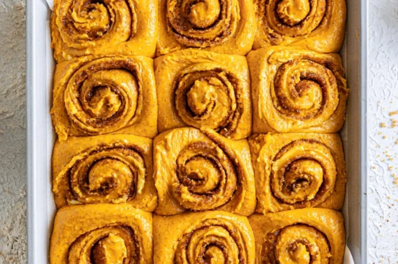 Delicious pumpkin cinnamon rolls topped with cream cheese icing, perfect for fall.