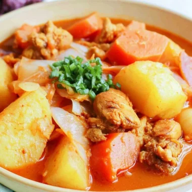 Bowl of spicy braised chicken stew with vegetables and herbs