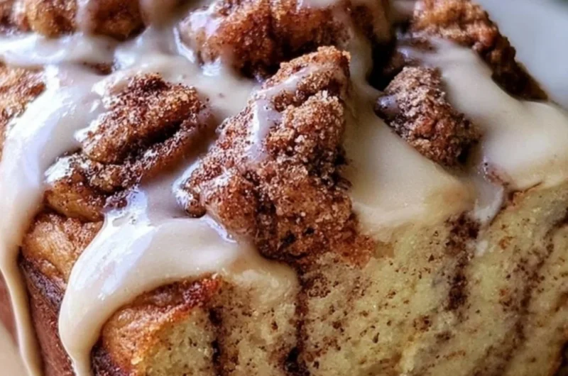 Cozy cinnamon roll banana bread fresh out of the oven topped with icing.
