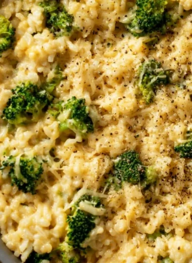 Cozy creamy broccoli cheese rice in a bowl with melted cheese on top
