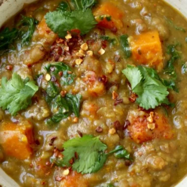 Bowl of earthy Moroccan sweet potato lentil stew with spices and vegetables