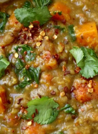 Bowl of earthy Moroccan sweet potato lentil stew with spices and vegetables