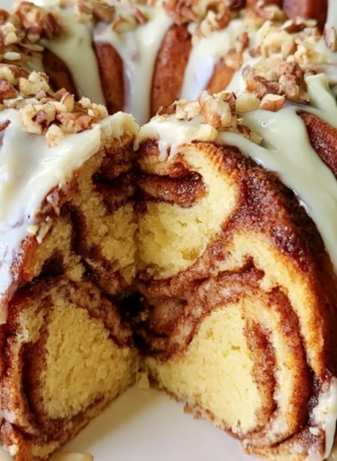 Easy Cinnamon Roll Bundt Cake with icing on a white cake stand