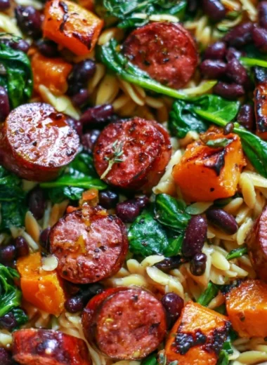 Butternut squash and black bean orzo with sausage and spinach in a bowl