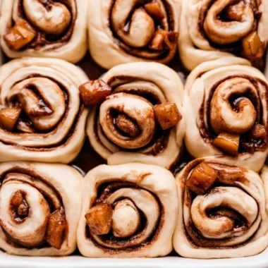Cozy apple pie cinnamon rolls with warm cinnamon and apple filling on a plate.