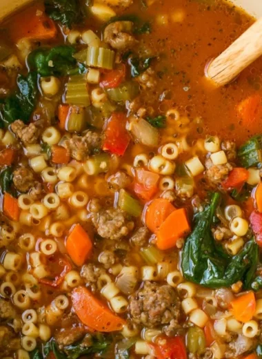 Bowl of cozy Italian sausage soup with vegetables and herbs