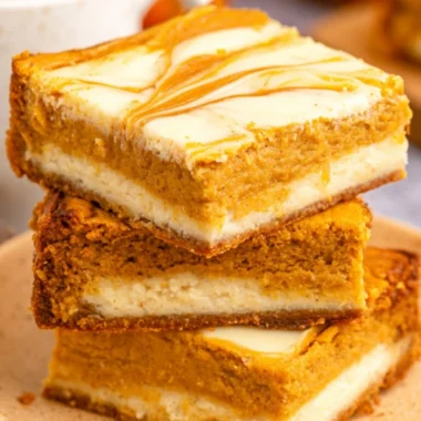 Cozy pumpkin cream cheese cheesecake bars topped with autumn spices.