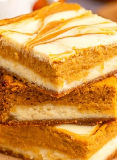 Cozy pumpkin cream cheese cheesecake bars topped with autumn spices.
