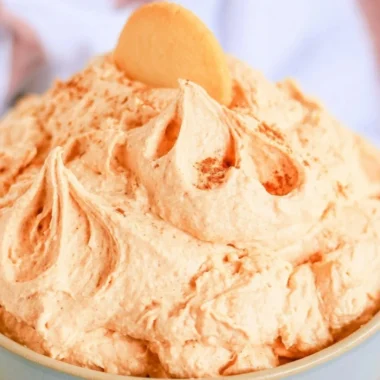 Delicious pumpkin cheesecake dip served in a bowl with graham crackers nearby.