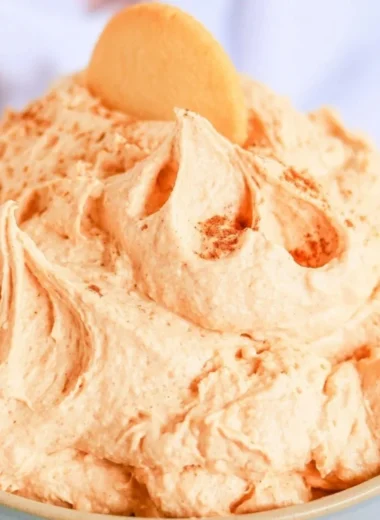 Delicious pumpkin cheesecake dip served in a bowl with graham crackers nearby.