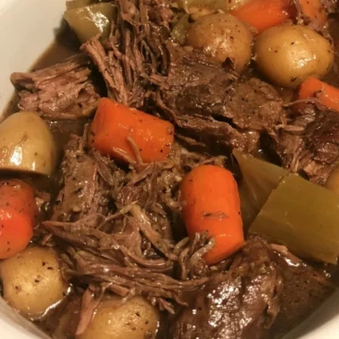 Delicious slow cooker pot roast with vegetables in a rustic dish