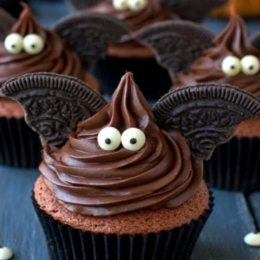 Halloween bat cupcakes decorated with chocolate and candy for a spooky treat.