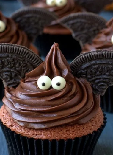 Halloween bat cupcakes decorated with chocolate and candy for a spooky treat.