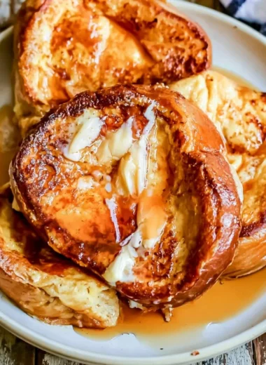 Delicious French toast topped with syrup and berries on a plate