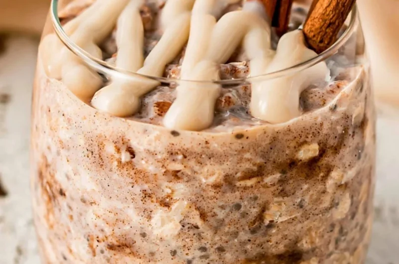 Bowl of cinnamon roll overnight oats topped with cinnamon and nuts