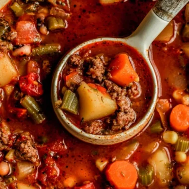 A bowl of hearty Cowboy Soup filled with beef, beans, and vegetables.