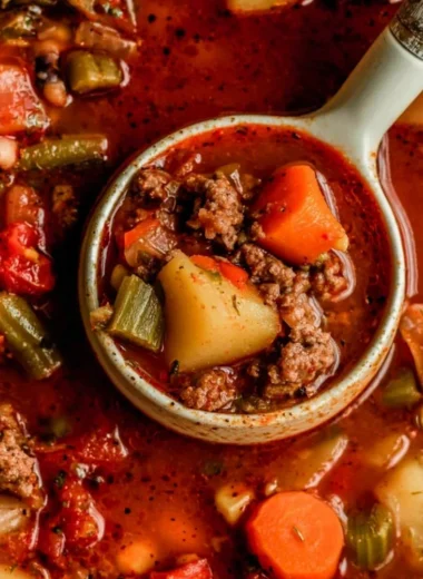 A bowl of hearty Cowboy Soup filled with beef, beans, and vegetables.
