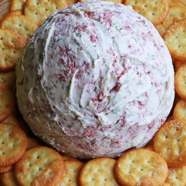 Delicious easy party cheese ball garnished with herbs and served with crackers.
