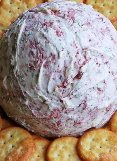 Delicious easy party cheese ball garnished with herbs and served with crackers.