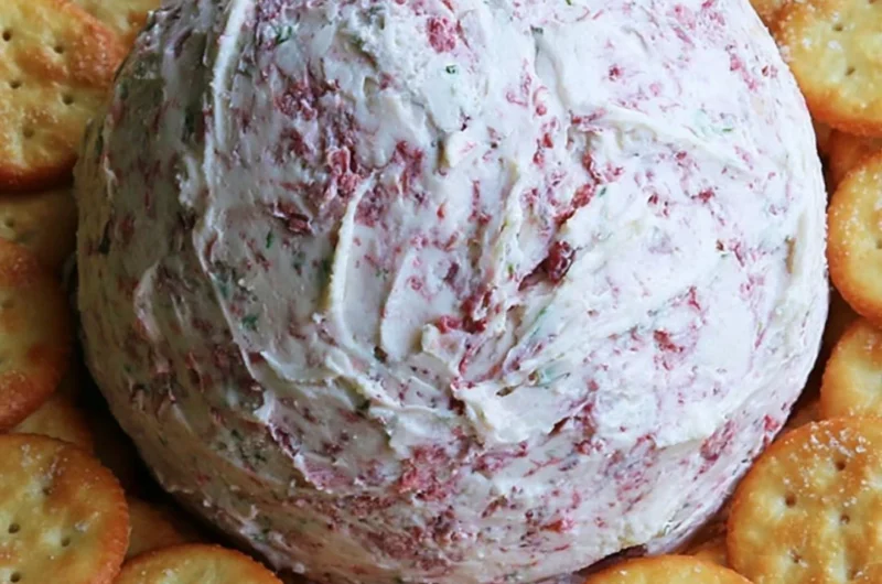 Delicious easy party cheese ball garnished with herbs and served with crackers.