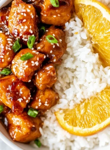 Healthy orange chicken bowl served with vegetables and rice, perfect for a quick meal.