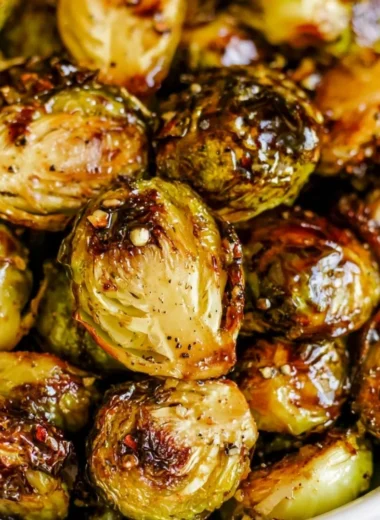Roasted Brussels sprouts with honey balsamic sauce on a white plate