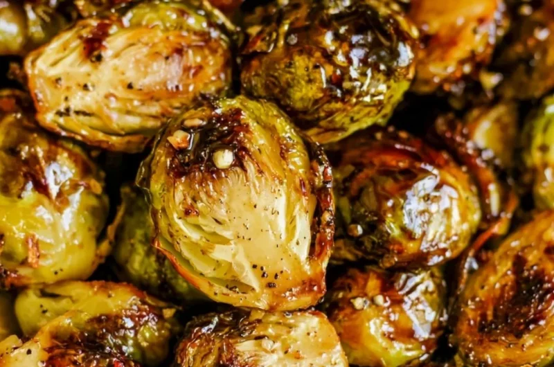 Roasted Brussels sprouts with honey balsamic sauce on a white plate