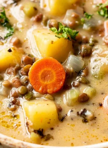 Bowl of delicious vegetarian lentil soup garnished with fresh herbs